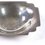 An Islamic silver coin inset dish, with engine turned decorated border, length 12cm, 2oz