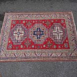 A Caucasian handmade red and blue ground geometric pattern rug, 6'8" x 4'10"