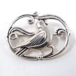 Mid 20th century Georg Jensen style Danish silver oval brooch depicting a bird amongst scrolling...