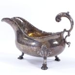 A George III silver gravy boat, with scrolled acanthus C-handle and hoof feet, possibly by George
