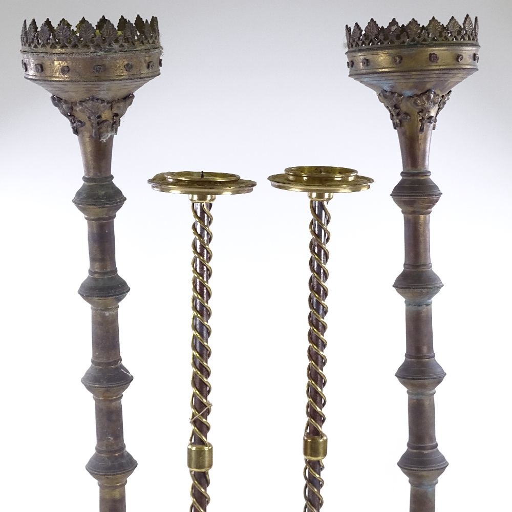 A pair of Victorian Gothic brass floor standing candle holders, height 95cm, and a pair of brass