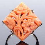 A 9ct gold relief carved coral panel ring, with floral decoration and pierced body, setting height