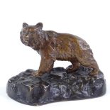 A small patinated bronze bear on rocky base, indistinctly signed, length 11cm