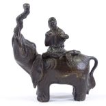 A Chinese patinated bronze incense burner, in the form of a figure seated on an elephant, height