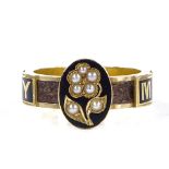 A Victorian 18ct gold black enamel and split-pearl memorial ring, with central floral panel, "