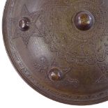 A Middle Eastern bronze shield with relief decoration, 27cm across