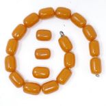 A string of polished barrel-shaped amber beads, bead length 24mm, necklace length 40cm, and 3