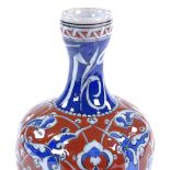 A Turkish red and blue glaze narrow-necked bottle with painted enamel decoration, height 19cm