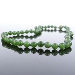 A single string of polished nephrite beads, on silver clasp, maker's marks JKa, necklace length