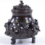 A Chinese patinated bronze incense burner, with relief cast leaf moulded surround, and original
