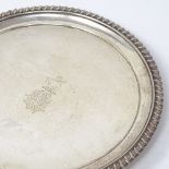 A George IV circular silver card tray, with gadrooned rim and lion paw feet, by Charles Fox II,