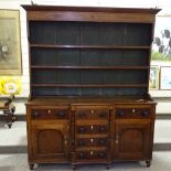 A George III oak and mahogany break-front Anglesea Welsh dresser, with boarded open plate rack and