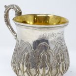 A Victorian unmarked silver half pint mug, with relief embossed leaf decoration and gilt interior,