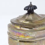 A George V squat silver tea caddy, with turned ebony handle and gilt interior, probably by Junior
