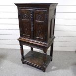 An Antique carved and panelled oak 2-door cupboard on stand, 33.5", height 5'6"
