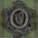 A Victorian carved bog oak Unity badge, with silver mount and shamrock rose and thistle designs,