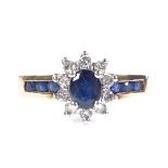 A 9ct gold sapphire and diamond cluster ring, with channel set sapphire shoulders, setting height