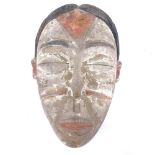 A Punu carved and painted wood Tribal mask, height 21cm