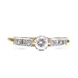 An 18ct gold 0.18ct solitaire diamond ring, with diamond set shoulders, setting height 3.9mm, size