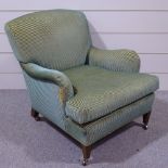 A Howard & Sons upholstered fireside armchair, with mahogany tapered legs and brass casters, green/