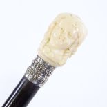 An ebony walking cane with carved ivory handle in the form of a child's head