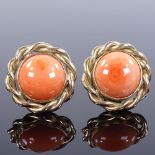 A pair of 9ct gold cabochon coral earrings, with clip fittings and rope twist surround, earring