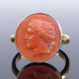 A silver-gilt relief carved coral panel ring, depicting Classical portrait, setting height 15.1mm,