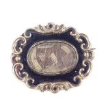 A Victorian unmarked yellow metal black enamel and woven hair panel mourning ring, with foliate