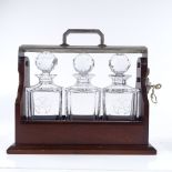 A mahogany and electroplate tantalus with 3 original cut-glass decanter, with key, length 31cm