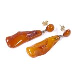 A pair of rough-cut amber drop pendant earrings, with 9ct gold stud fittings, earring height 47.6mm,