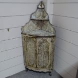 An 18th century Maltese painted and carved pine bow-front corner cupboard, with open shelves above