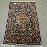 A small blue ground wool rug, with floral decoration and red border, 150cm x 90cm
