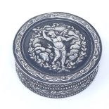 A small Continental circular silver box, with relief embossed cherub hinged lid and floral and