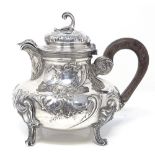 A French silver chocolate pot, with relief embossed foliate decoration, scrollwork knop and turned