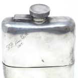 A George V curved silver spirit flask, with screw cap and removable cup with gilt interior, by