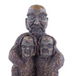 A Japanese earthenware Taka Nyudo (tall priest) holding 2 people, possibly Meiji Period, height 28cm