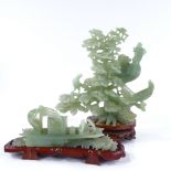 A Chinese carved jadeite peacock sculpture, height 19cm, and a jadeite boat on hardwood stand (2)