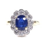 An 18ct gold sapphire and diamond cluster ring, oval-cut sapphire approx 1.59ct, total diamond