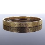 A 9ct gold slave bangle, with engine turned decoration, maker's marks MPG, band width 8mm,