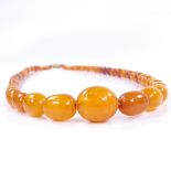 A string of graduated polished butterscotch amber beads, largest bead length 19.8mm, necklace length