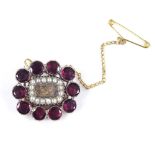 A Victorian unmarked gold flat-top garnet split-pearl and woven hair panel mourning brooch, with