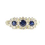 An 18ct gold sapphire and diamond triple-cluster ring, with ribbed shoulders, maker's stamp B