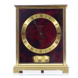 A Jaeger LeCoultre Embassy Atmos clock, with red lacquer simulated tortoiseshell dial, case height