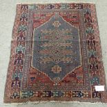 A small Caucasian red ground wool rug, 115cm x 95cm