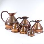 A graduated set of copper measuring jugs, largest 2 gallon, height to rim 31cm
