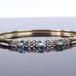 A 9ct gold blue topaz and diamond bangle, band width 4.4mm, internal diameter 62mm, internal