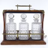 A Victorian walnut and brass-mounted tantalus, containing 3 original square cut-glass decanters