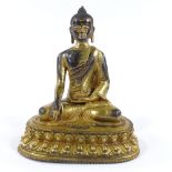 A Chinese gilt-bronze seated deity on lotus flower decorated base, height 20cm
