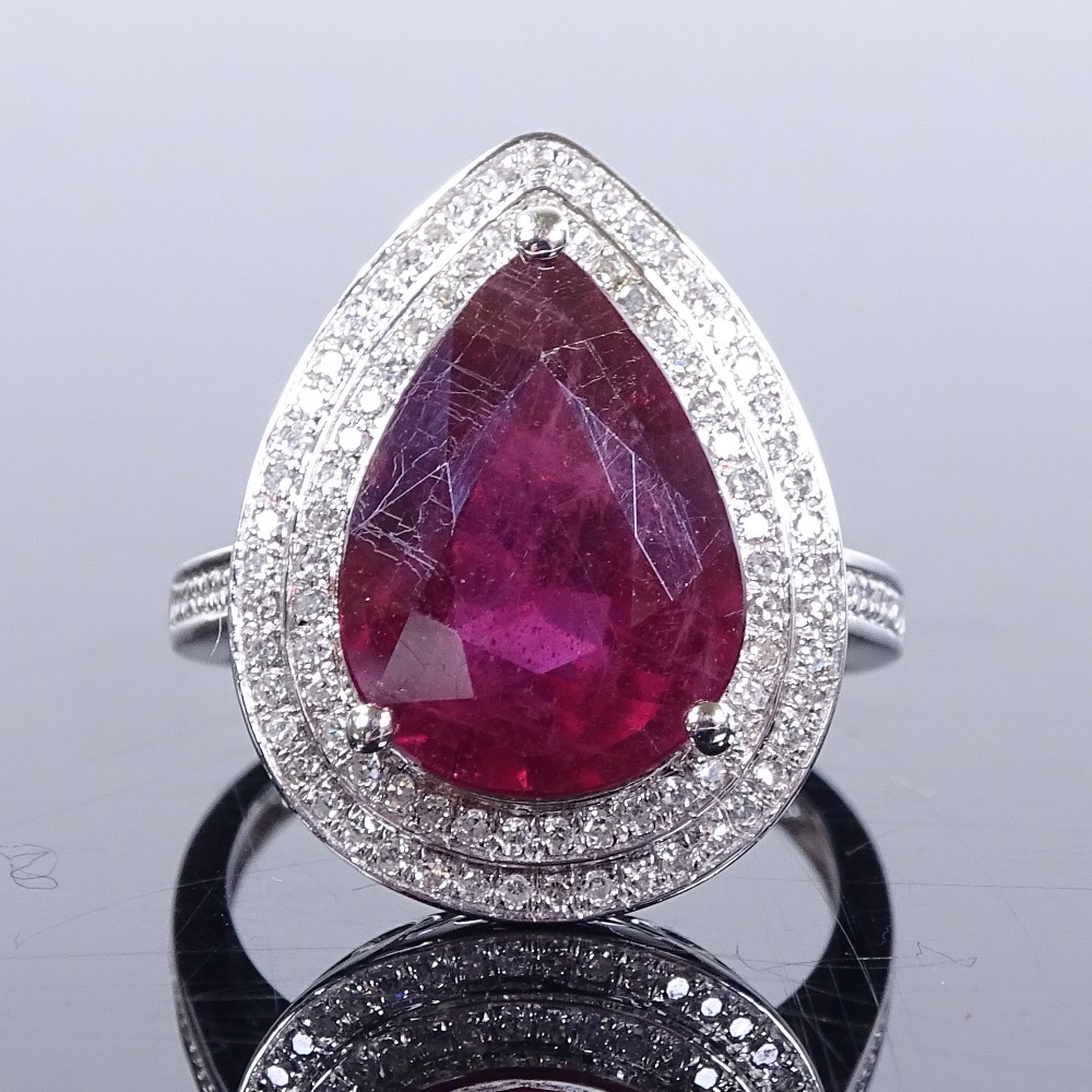 A 14ct white gold ruby and diamond cluster ring, pear-cut ruby approx 7.43ct, total diamond