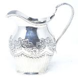A late Victorian silver cream jug, of half-fluted form with relief embossed floral swags, maker's